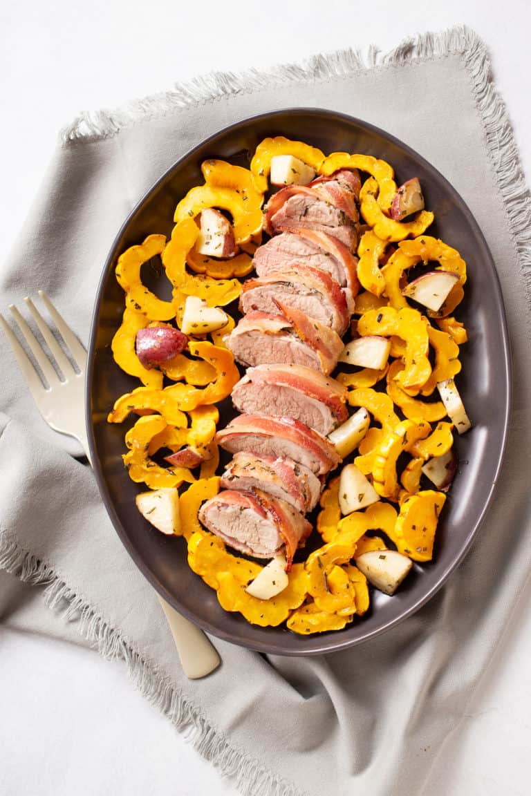 bacon-wrapped pork tenderloin slices with delicata squash and potatoes